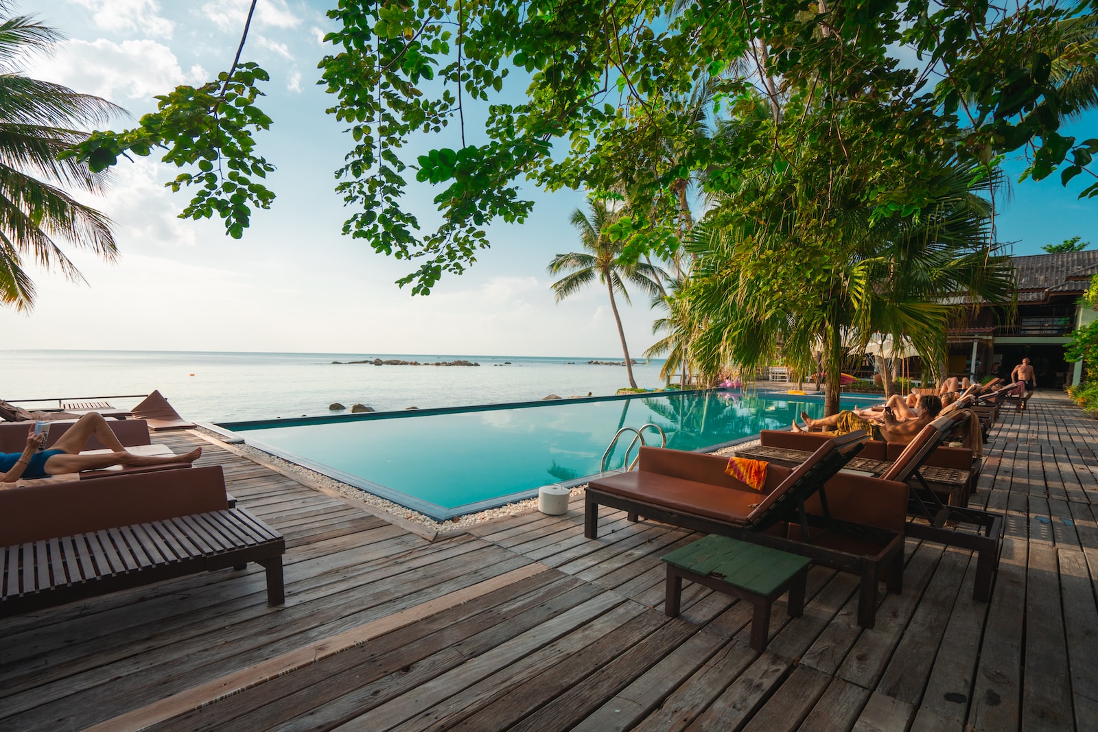 brown wooden table and chairs on brown wooden deck near body of water during daytime